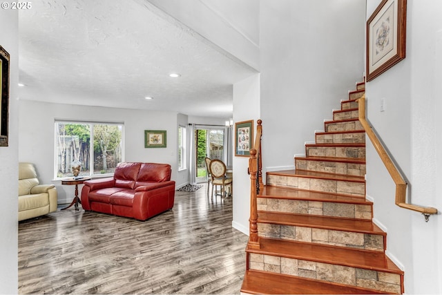 stairs featuring recessed lighting, a textured ceiling, baseboards, and wood finished floors