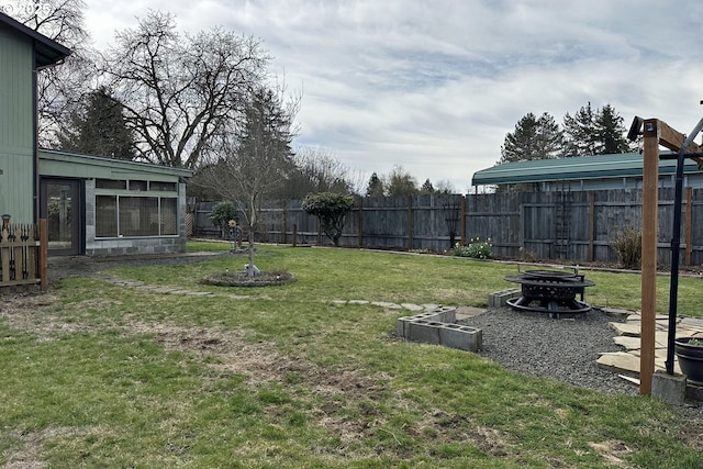 view of yard with an outdoor fire pit and a sunroom