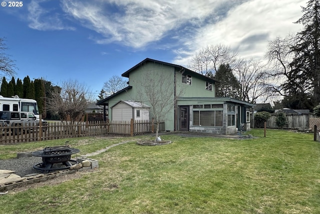 rear view of house with an outdoor fire pit and a sunroom