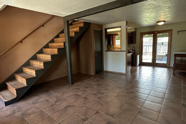 stairway with tile patterned floors, baseboards, and french doors