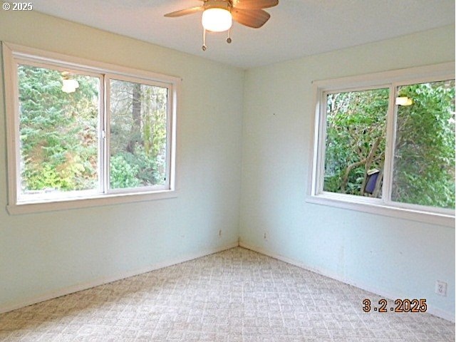 carpeted spare room featuring ceiling fan