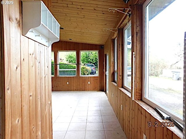 unfurnished sunroom featuring wood ceiling and vaulted ceiling