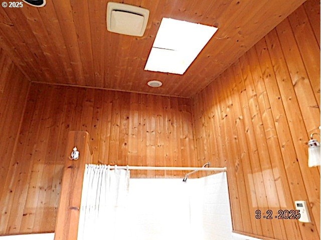 interior details with wood walls, wooden ceiling, and a skylight