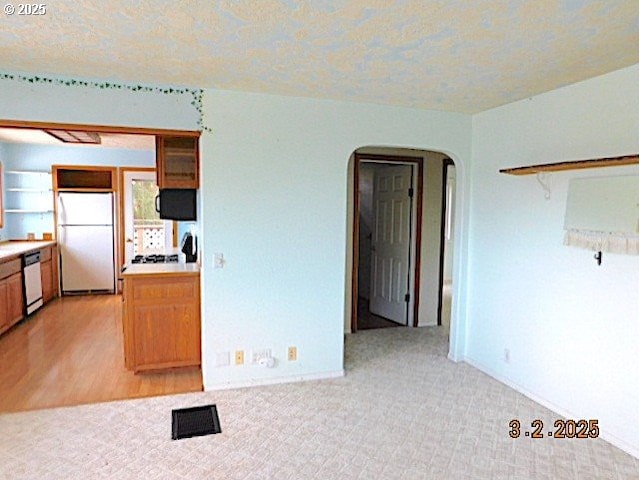 kitchen with light carpet, white appliances, arched walkways, light countertops, and open shelves