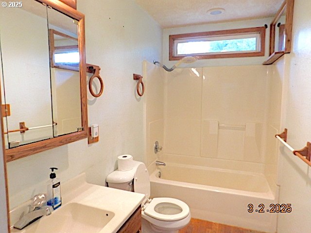 full bathroom with bathtub / shower combination, vanity, and toilet