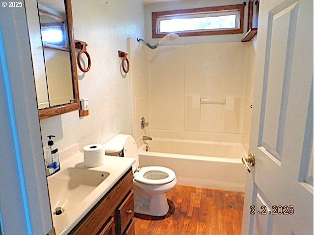 full bath with shower / bathtub combination, vanity, wood finished floors, and toilet