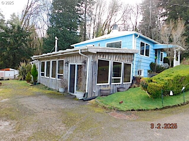 view of front of home featuring a front lawn, board and batten siding, and a chimney