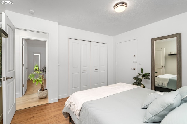 bedroom with light hardwood / wood-style floors and a textured ceiling