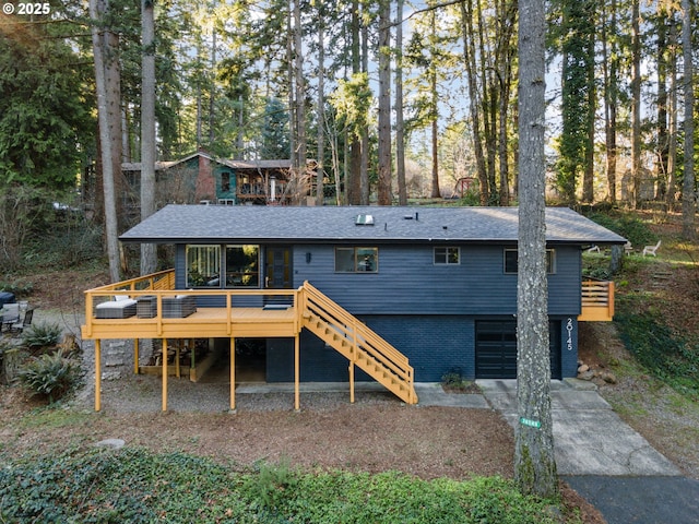 back of house with a garage and a deck