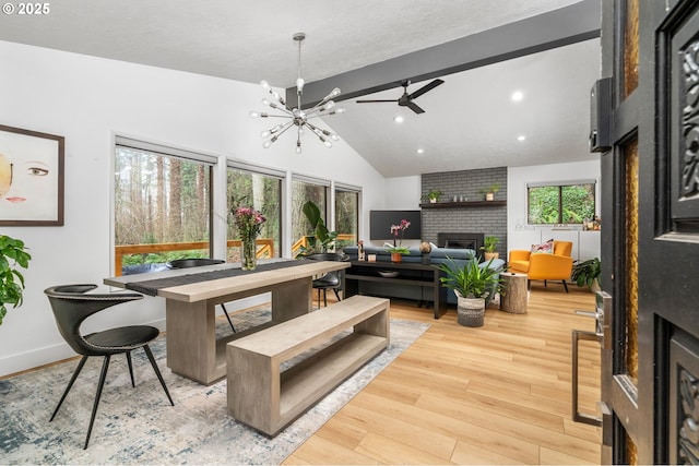 living room with lofted ceiling, a fireplace, light hardwood / wood-style floors, and plenty of natural light