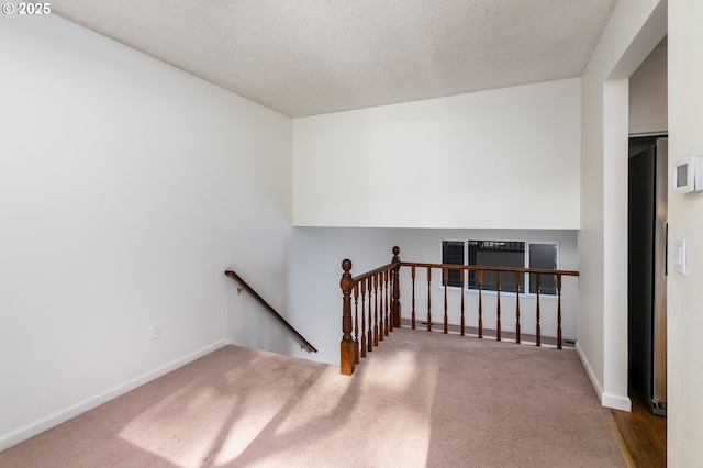 stairs featuring carpet floors and a textured ceiling