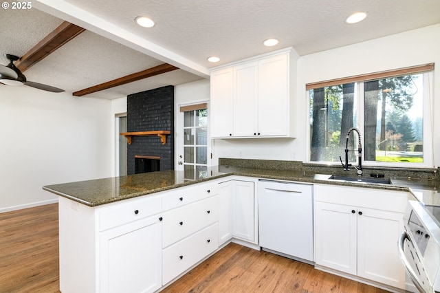 kitchen featuring dishwasher, sink, white cabinets, light hardwood / wood-style floors, and kitchen peninsula