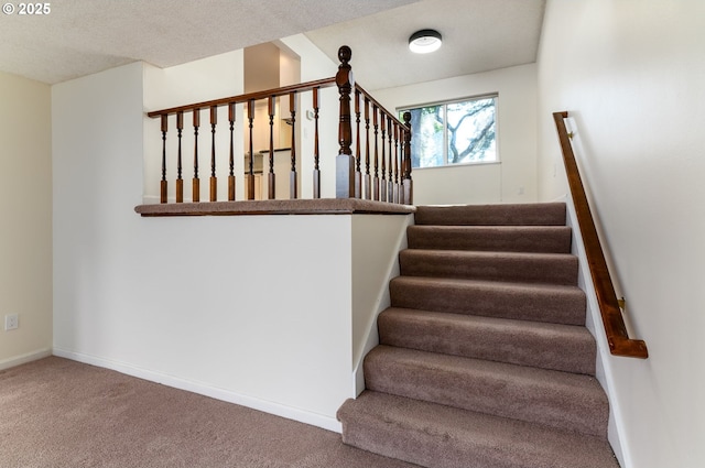 stairs featuring carpet flooring and a textured ceiling