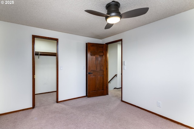 unfurnished bedroom featuring ceiling fan, light carpet, a textured ceiling, and a closet