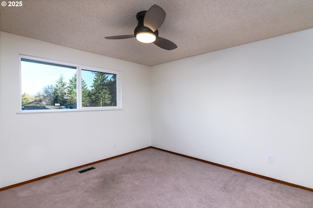 carpeted spare room with ceiling fan and a textured ceiling