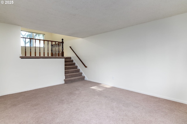 unfurnished living room with carpet and a textured ceiling