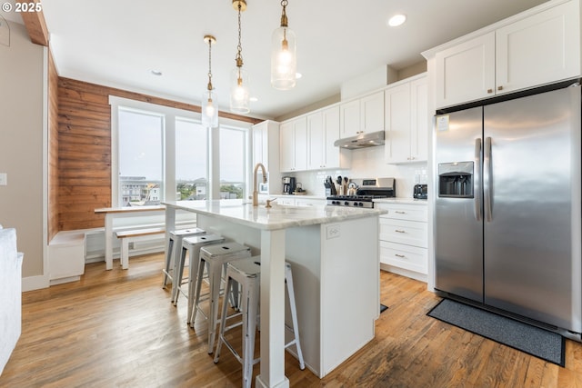 2539 SW Coral Loop, Lincoln City, OR 97367 - kitchen featuring stainless steel appliances, under cabinet range hood, a kitchen island with sink, white cabinets, and recessed lighting