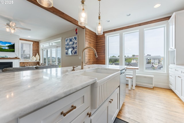 2539 SW Coral Loop, Lincoln City, OR 97367 - kitchen with open floor plan, light wood-style flooring, a ceiling fan, white cabinetry, and decorative light fixtures