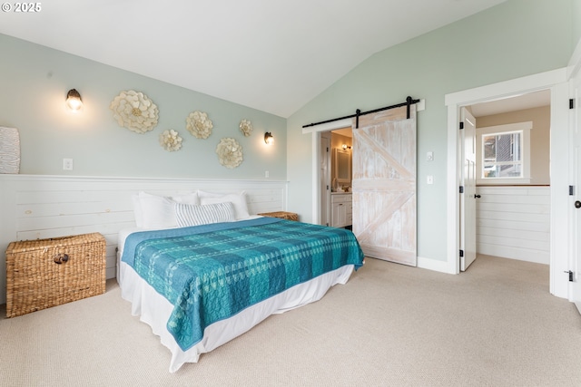 2539 SW Coral Loop, Lincoln City, OR 97367 - carpeted bedroom featuring a barn door, vaulted ceiling, and ensuite bathroom