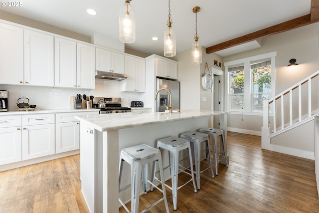 2539 SW Coral Loop, Lincoln City, OR 97367 - kitchen featuring under cabinet range hood, appliances with stainless steel finishes, white cabinetry, light wood-style floors, and recessed lighting