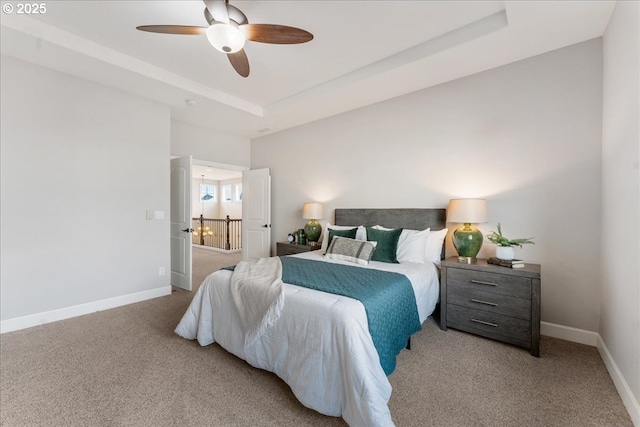 bedroom featuring carpet floors, ceiling fan, and a tray ceiling