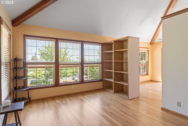 interior space featuring baseboards, lofted ceiling with beams, and light wood-style floors