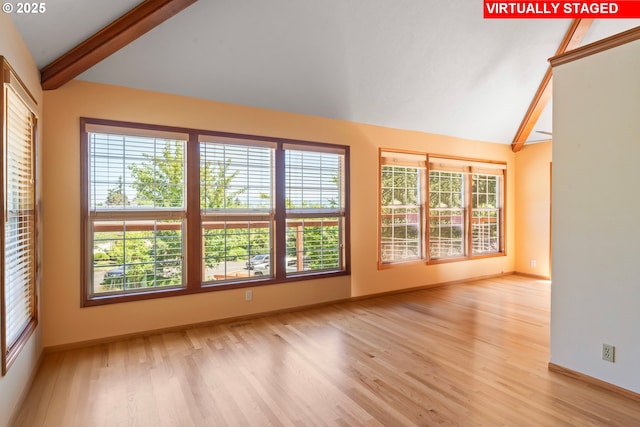 interior space featuring baseboards, vaulted ceiling with beams, and light wood-type flooring