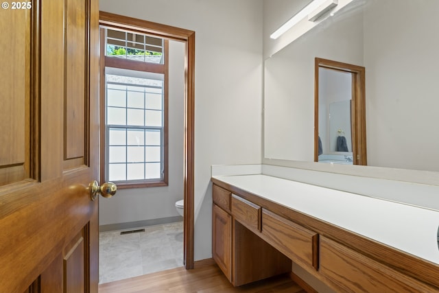 bathroom with toilet, baseboards, visible vents, and vanity