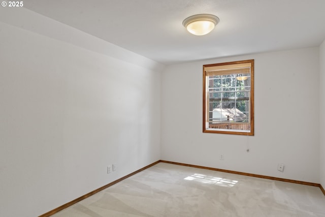 empty room with baseboards and light carpet