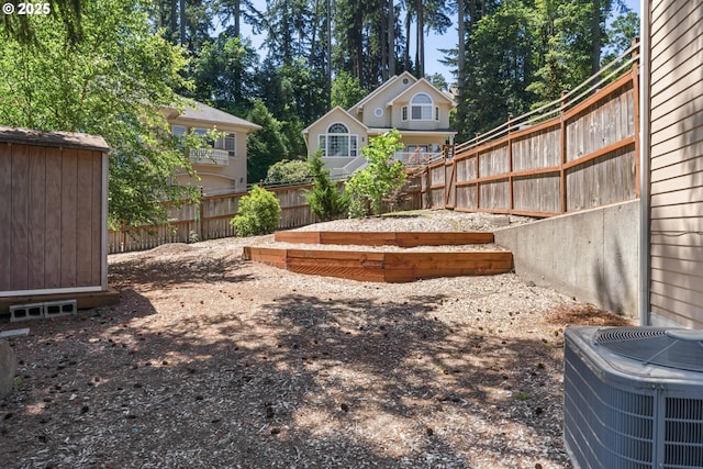 view of yard featuring central AC, fence, and an outbuilding