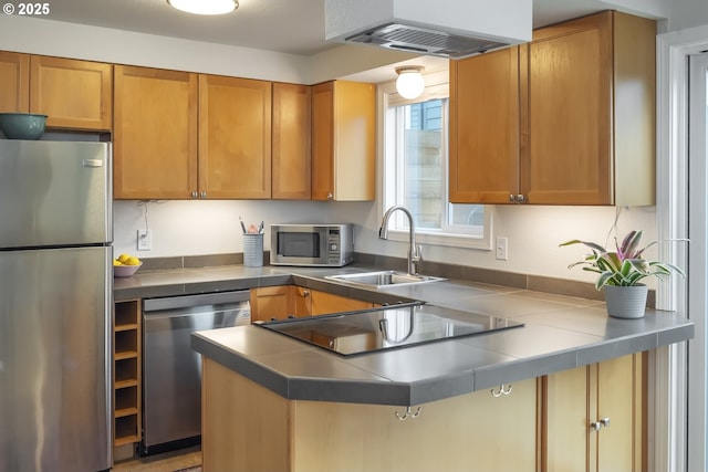 109 NE Shaver Ave, Portland, OR 97212 - kitchen featuring appliances with stainless steel finishes, extractor fan, a sink, a peninsula, and brown cabinets