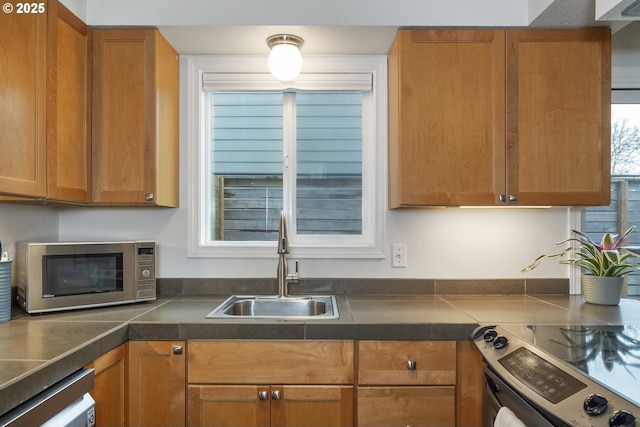 109 NE Shaver Ave, Portland, OR 97212 - kitchen with stainless steel appliances, a sink, brown cabinetry, and dark countertops
