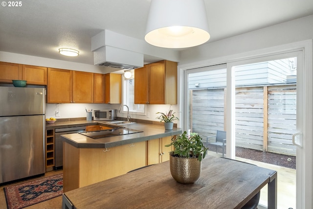 109 NE Shaver Ave, Portland, OR 97212 - kitchen with stainless steel appliances, a sink, a peninsula, brown cabinets, and dark countertops
