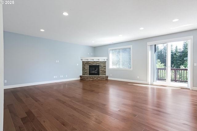 17067 NW Catalpa St, Portland, OR 97229 - unfurnished living room featuring wood finished floors, a stone fireplace, baseboards, and recessed lighting