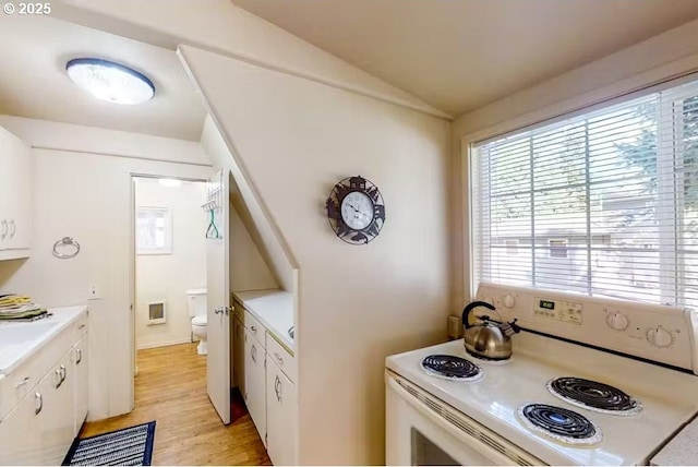 kitchen with white cabinetry, lofted ceiling, light hardwood / wood-style flooring, and white range with electric cooktop