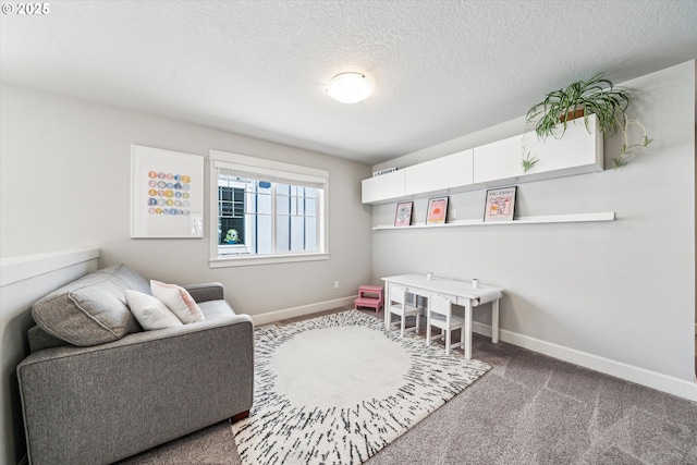 recreation room featuring baseboards, a textured ceiling, and carpet flooring