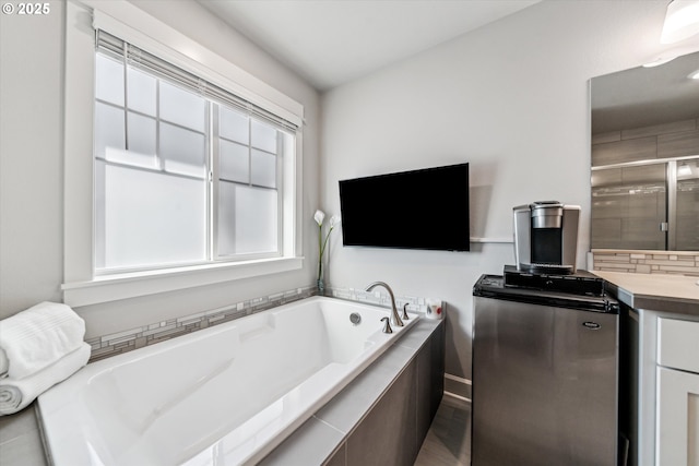 bathroom featuring vanity, a shower stall, and a bath