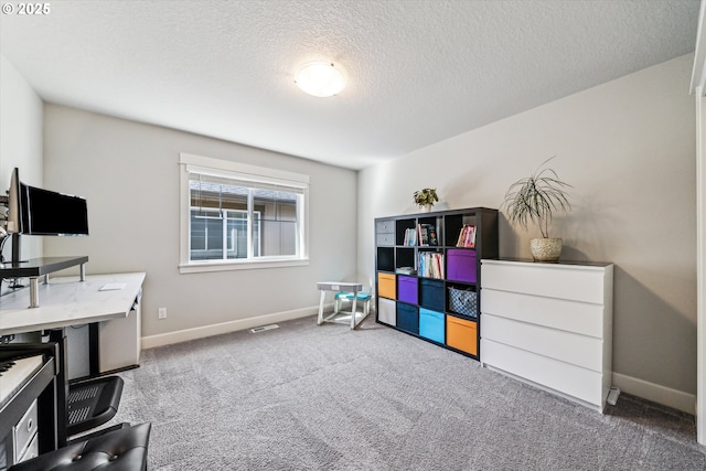 office featuring carpet floors, visible vents, baseboards, and a textured ceiling