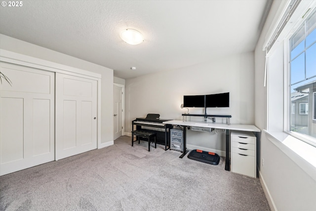 office space with carpet flooring, a textured ceiling, and baseboards