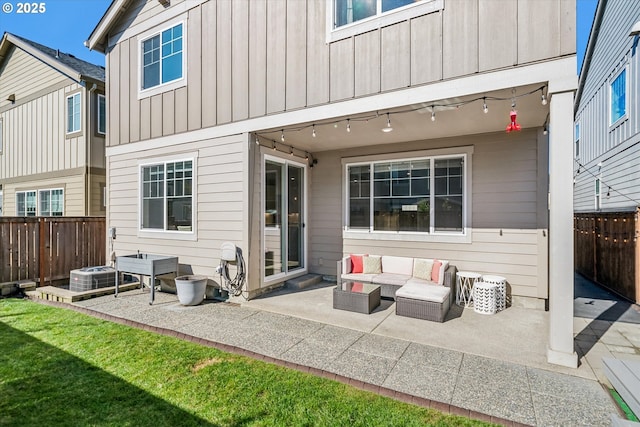 back of house with a patio, a lawn, an outdoor hangout area, board and batten siding, and a fenced backyard