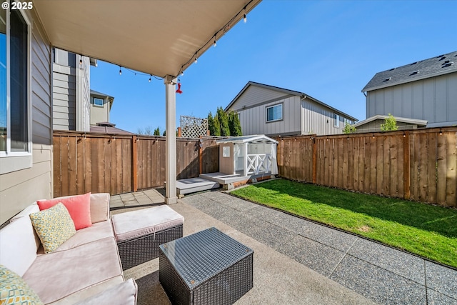 view of patio / terrace featuring a fenced backyard, a storage unit, outdoor lounge area, and an outbuilding