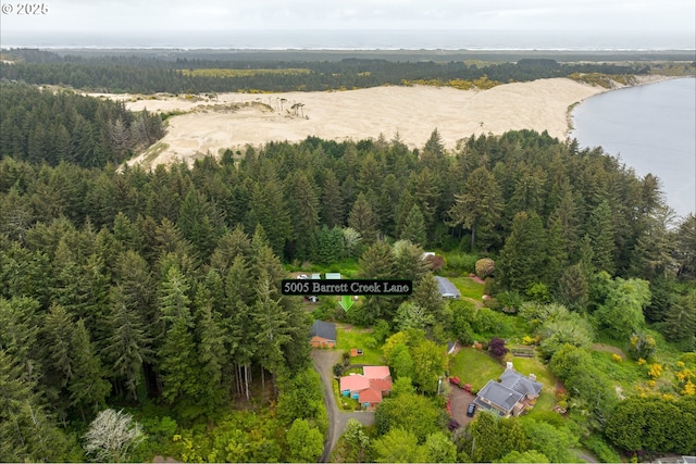 drone / aerial view of a heavily wooded area and a nearby body of water