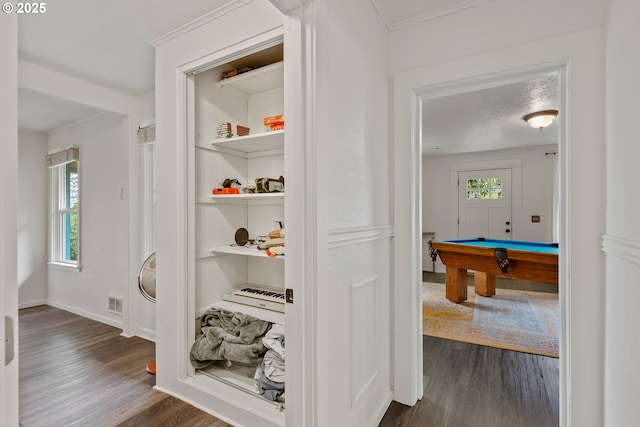 hall featuring dark wood-style flooring, crown molding, and baseboards