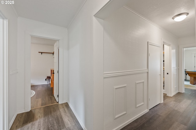 hallway featuring ornamental molding and dark wood-style floors