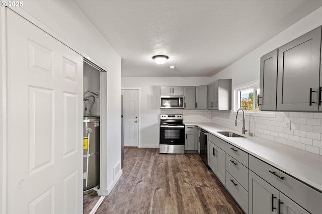 320 Beech St, Longview, WA 98632 - kitchen with stainless steel appliances, gray cabinets, a sink, strapped water heater, and backsplash