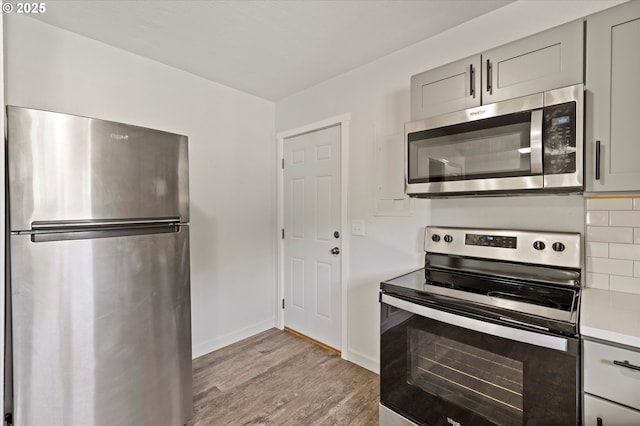 320 Beech St, Longview, WA 98632 - kitchen featuring stainless steel appliances, gray cabinetry, light wood finished floors, light countertops, and baseboards