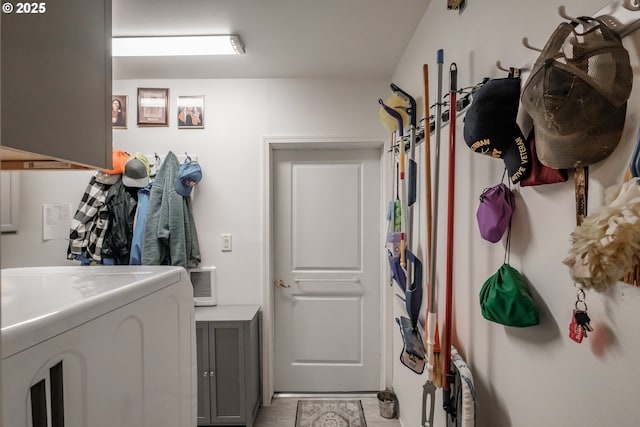 clothes washing area with washer / clothes dryer and cabinets