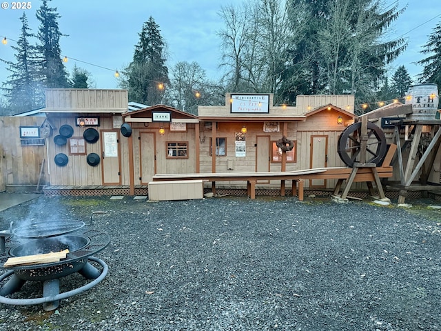 rear view of property with a fire pit