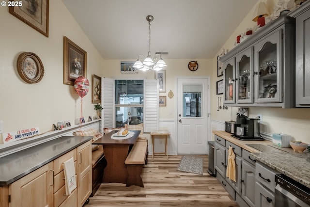 kitchen with gray cabinets, light hardwood / wood-style floors, light brown cabinetry, and an inviting chandelier