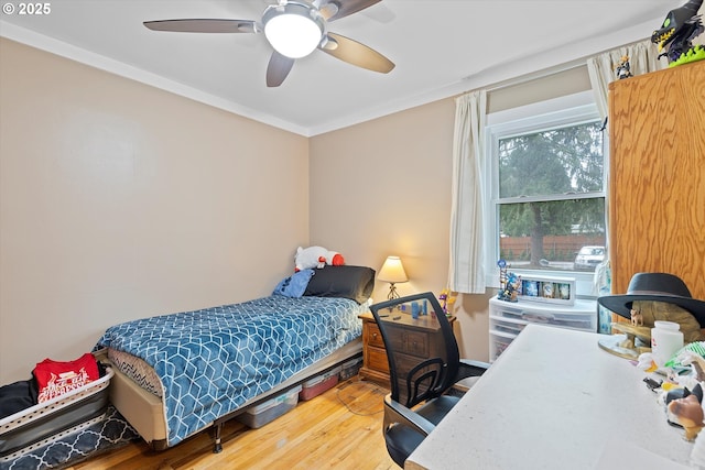 bedroom with crown molding, hardwood / wood-style floors, and ceiling fan